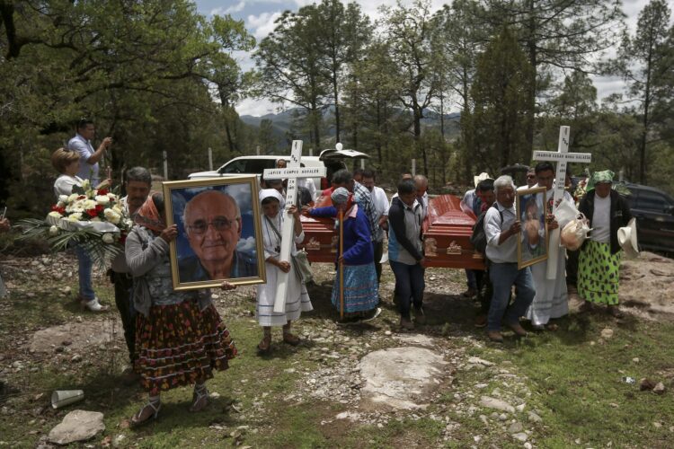Neighbors receive the funeral procession of Jesuit priests Javier Campos Morales and Joaquin Cesar Mora Salazar in Cerocahui, Chihuahua state, Mexico, Sunday, June 26, 2022. The two elderly priests and a tour guide murdered in Mexico's Sierra Tarahumara this week are the latest in a long line of activists, reporters, travelers and local residents who have been threatened or killed by criminal gangs that dominate the region. (AP Photo/Christian Chavez)